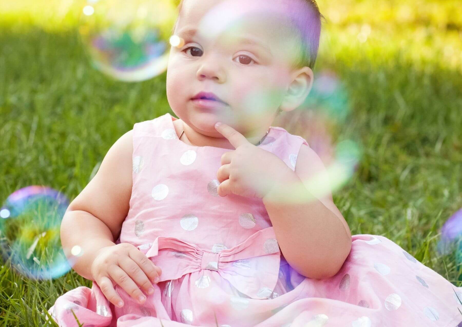 Baby at ceremony watching bubbles blown