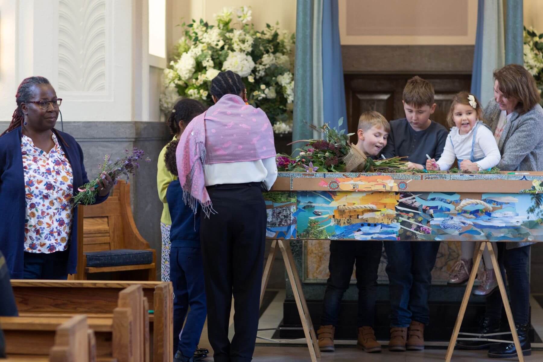 Mourners decorating a coffin